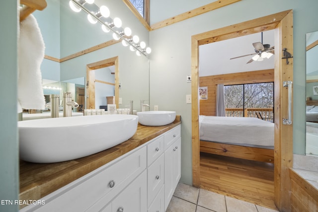 ensuite bathroom featuring double vanity, a sink, connected bathroom, and a ceiling fan