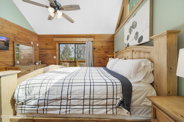 bedroom with ceiling fan, wood walls, access to exterior, and lofted ceiling