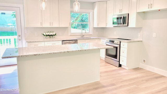 1805 Ferd Hickey Rd, Knoxville, TN 37909 - kitchen with appliances with stainless steel finishes, pendant lighting, a center island, a sink, and light wood-type flooring