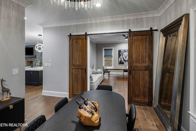 8947 Linksvue Dr, Knoxville, TN 37922 - dining room with a barn door, wood finished floors, and crown molding