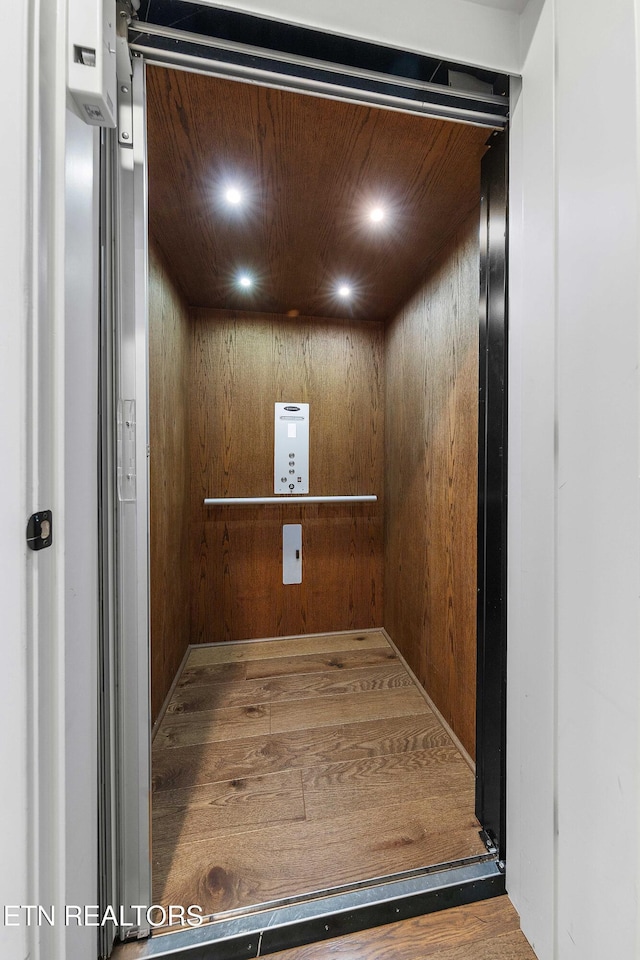 8947 Linksvue Dr, Knoxville, TN 37922 - details with wood walls, wood finished floors, elevator, and recessed lighting
