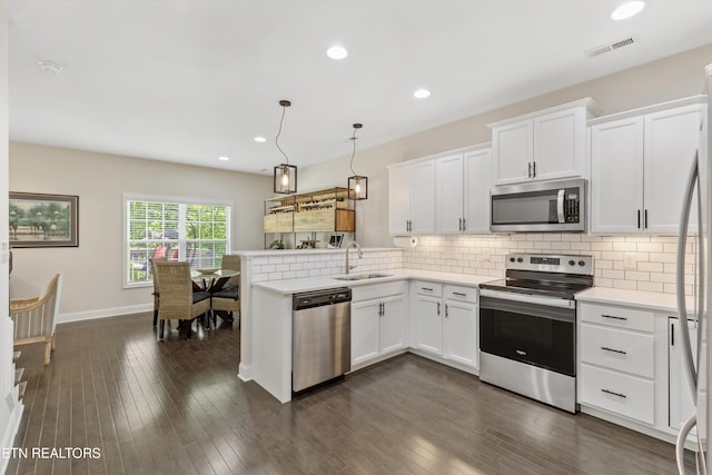 6749 Albatross Ln, Knoxville, TN 37921 - kitchen featuring stainless steel appliances, a sink, a peninsula, white cabinetry, and recessed lighting