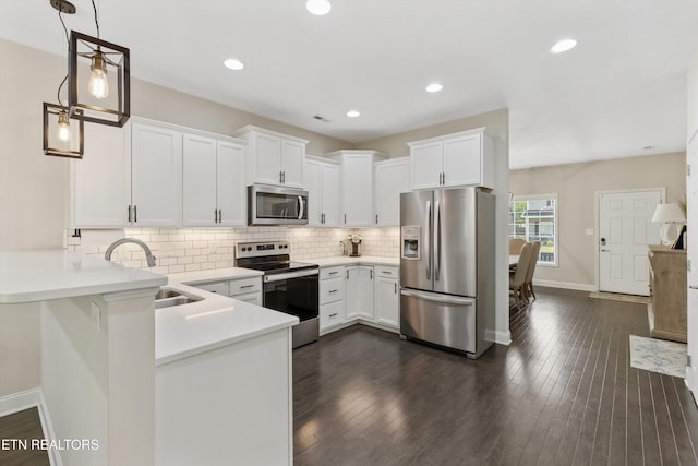 6749 Albatross Ln, Knoxville, TN 37921 - kitchen with stainless steel appliances, a sink, a peninsula, baseboards, and light countertops
