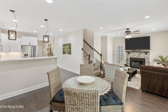 6749 Albatross Ln, Knoxville, TN 37921 - dining area featuring dark wood finished floors, stairway, ceiling fan, a fireplace, and recessed lighting