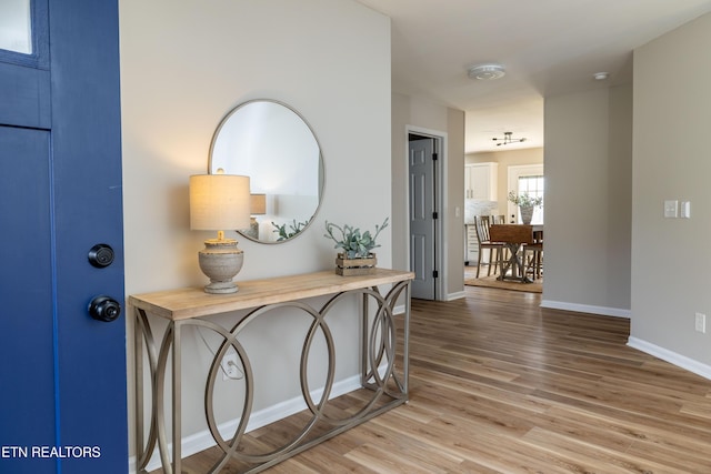 corridor with baseboards and wood finished floors