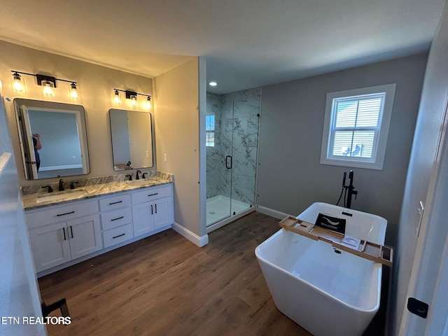 257 Colby Cir, Crossville, TN 38571 - bathroom featuring wood finished floors, a shower stall, double vanity, a sink, and a soaking tub