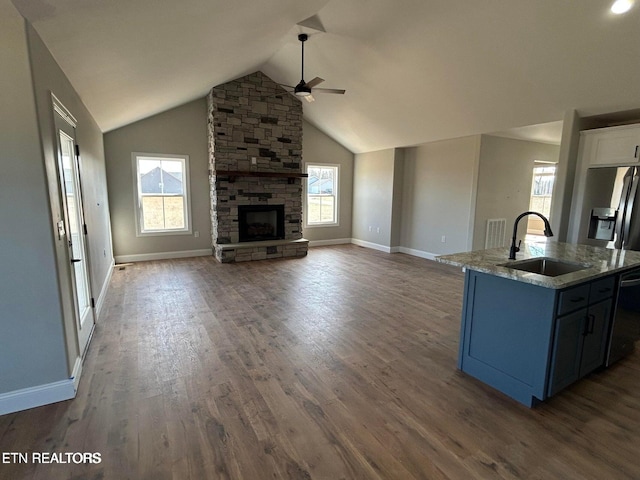 257 Colby Cir, Crossville, TN 38571 - living area featuring ceiling fan, a stone fireplace, vaulted ceiling, baseboards, and wood finished floors