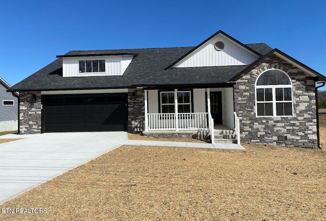 257 Colby Cir, Crossville, TN 38571 - view of front of house with driveway, stone siding, roof with shingles, covered porch, and a garage