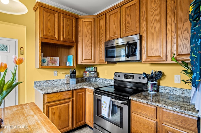 kitchen featuring light stone countertops, appliances with stainless steel finishes, brown cabinetry, and open shelves