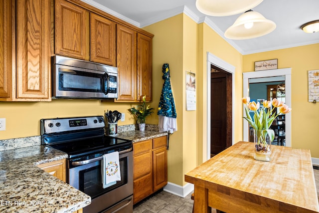 kitchen featuring brown cabinetry, crown molding, baseboards, light stone counters, and stainless steel appliances