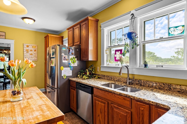 kitchen featuring wooden counters, crown molding, brown cabinets, a sink, and stainless steel appliances