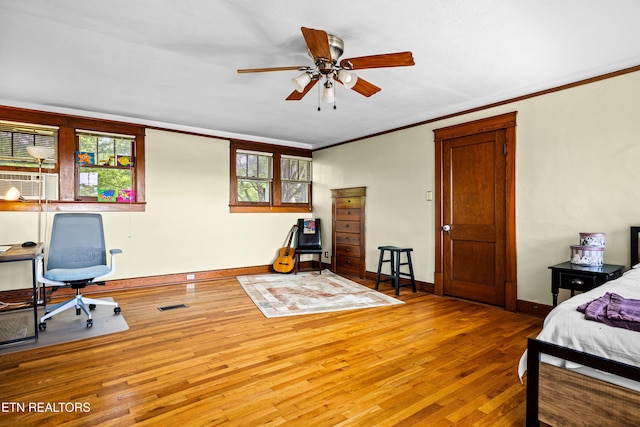 bedroom featuring visible vents, ornamental molding, baseboards, and hardwood / wood-style floors