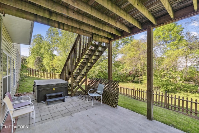 view of patio / terrace featuring a hot tub, stairs, and a fenced backyard