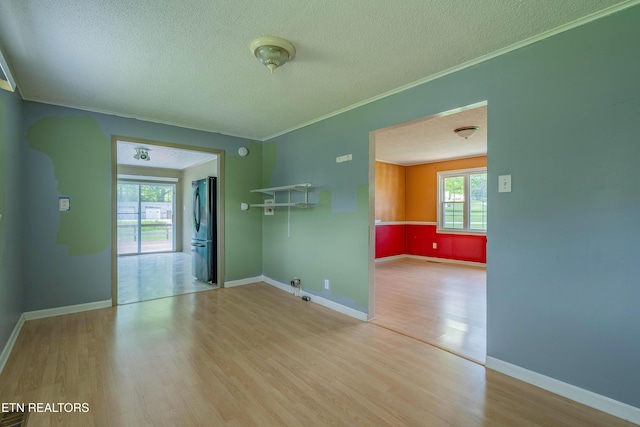 unfurnished room with crown molding, a textured ceiling, and wood finished floors