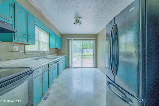 kitchen with a sink, freestanding refrigerator, visible vents, light countertops, and electric stove