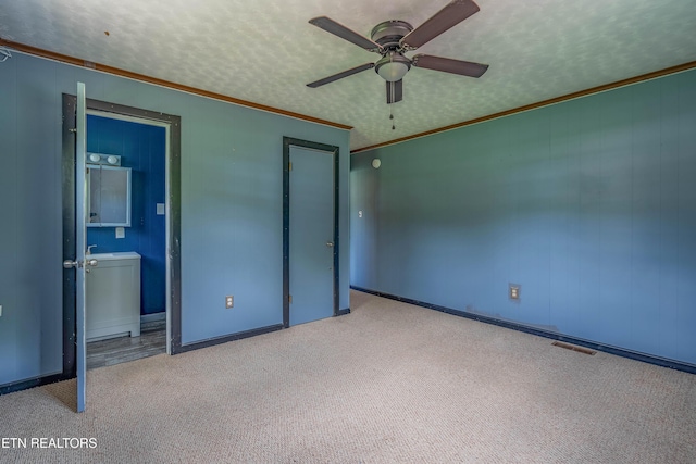 unfurnished bedroom with ornamental molding, visible vents, carpet floors, connected bathroom, and baseboards