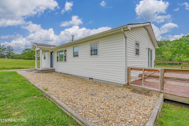 view of home's exterior with a yard, a deck, and crawl space