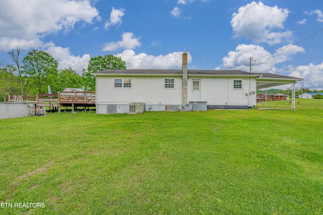 back of property featuring a yard, a deck, and an attached carport