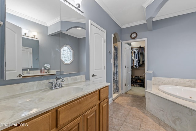 full bath featuring crown molding, vanity, a spacious closet, a garden tub, and a stall shower