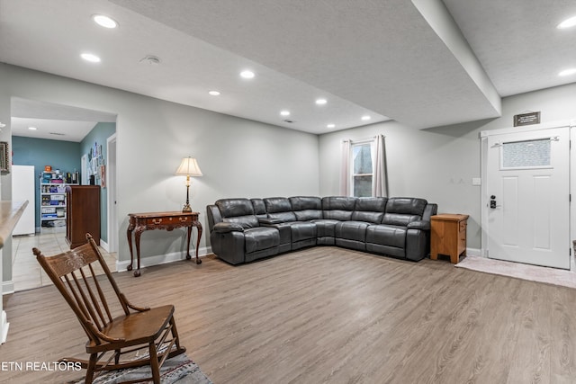 living area with recessed lighting, baseboards, and light wood-type flooring