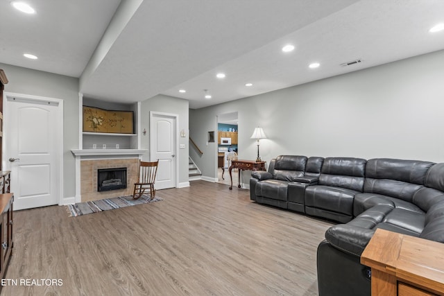 living room with stairs, recessed lighting, baseboards, wood finished floors, and visible vents