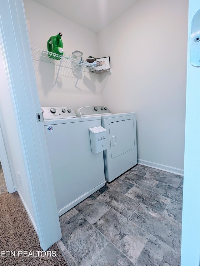 laundry room with washing machine and clothes dryer, baseboards, and laundry area