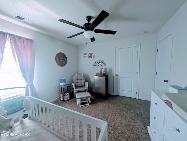 bedroom with baseboards, dark carpet, ceiling fan, and visible vents