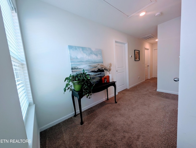 corridor with attic access, visible vents, recessed lighting, carpet flooring, and baseboards