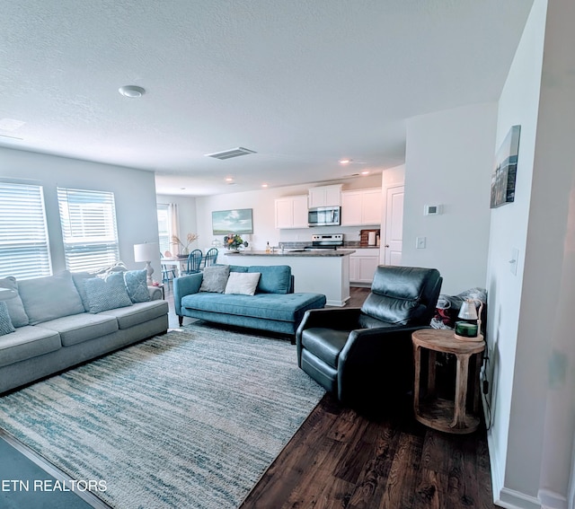living room with visible vents, dark wood-style flooring, and recessed lighting