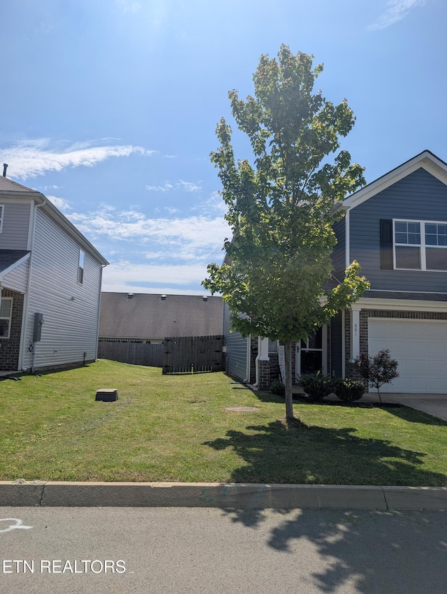 view of yard featuring an attached garage and fence