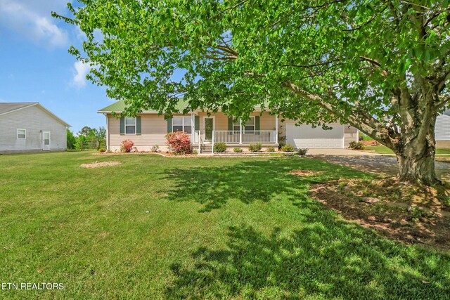 1228 Allardt Hwy, Jamestown, TN 38556 - view of front of house featuring covered porch, a front yard, an attached garage, dirt driveway, and metal roof