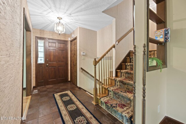 entrance foyer with stairway and a notable chandelier