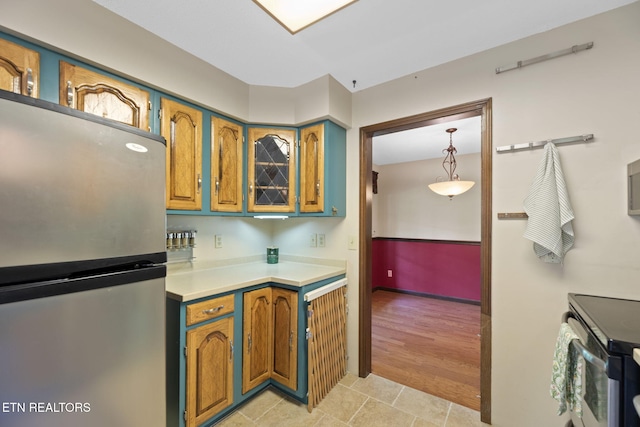 kitchen with light countertops, stainless steel appliances, brown cabinets, and baseboards