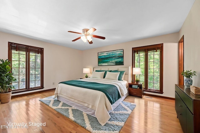 bedroom featuring baseboards, light wood-style flooring, and visible vents