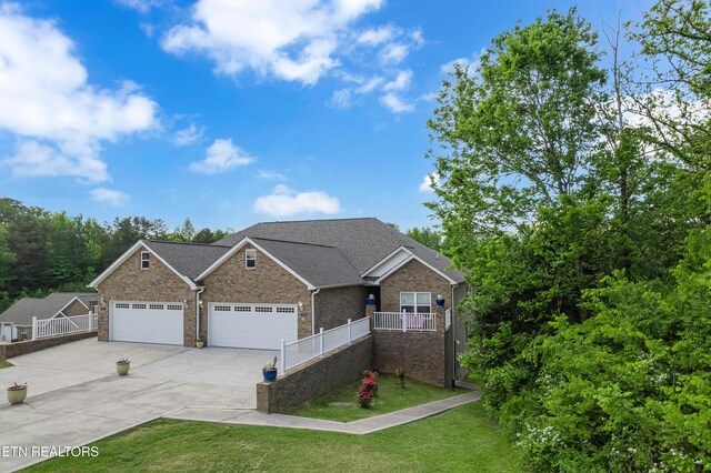 view of front of property with fence, brick siding, a garage, a front yard, and driveway