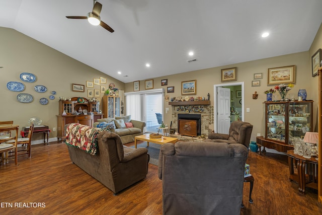 living area featuring visible vents, ceiling fan, dark wood-style floors, and a stone fireplace
