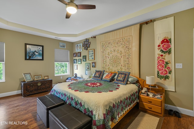bedroom featuring baseboards, ceiling fan, wood finished floors, and visible vents