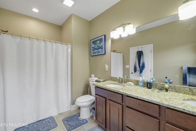 full bath with a sink, tile patterned flooring, toilet, and double vanity