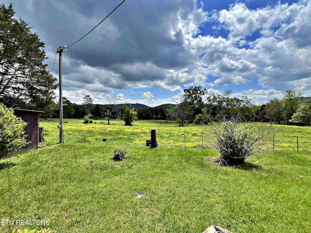 view of yard with a mountain view and fence