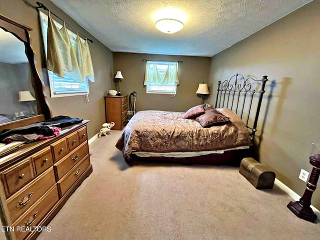 bedroom featuring baseboards, carpet floors, and a textured ceiling