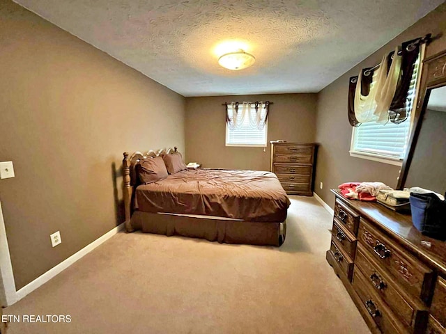 carpeted bedroom with a textured ceiling and baseboards