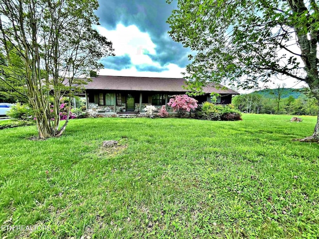 view of front of house featuring covered porch and a front lawn