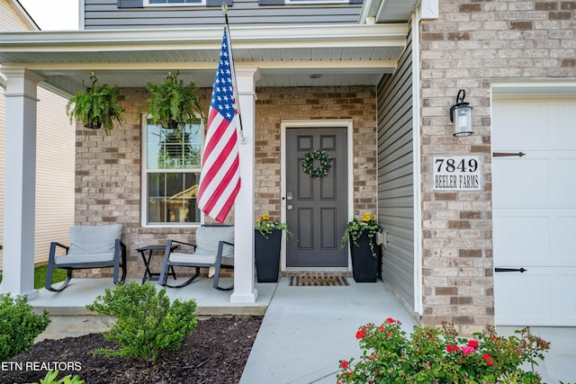 7849 Beeler Farms Ln, Knoxville, TN 37918 - doorway to property with a porch, an attached garage, and brick siding