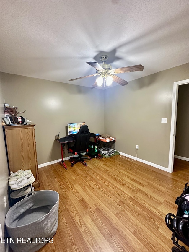 office area featuring baseboards, a ceiling fan, a textured ceiling, and wood finished floors