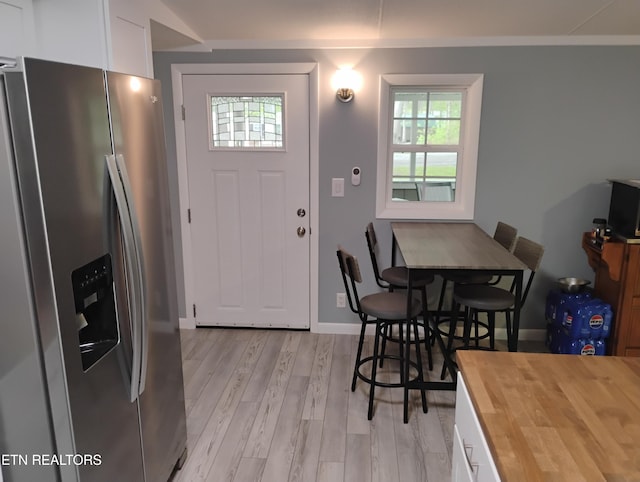 dining area featuring baseboards and light wood finished floors