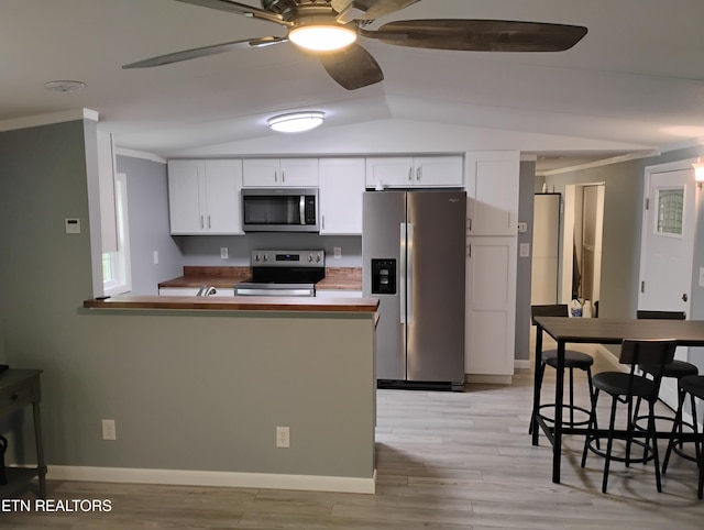 kitchen with white cabinets, ornamental molding, appliances with stainless steel finishes, and ceiling fan