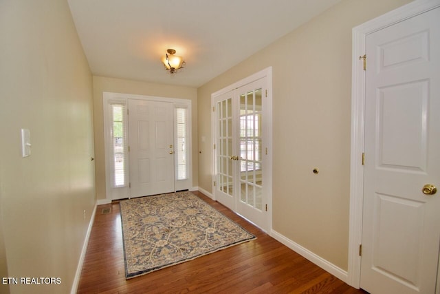 entryway with a healthy amount of sunlight, baseboards, and wood finished floors