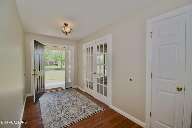 foyer featuring baseboards, wood finished floors, and french doors