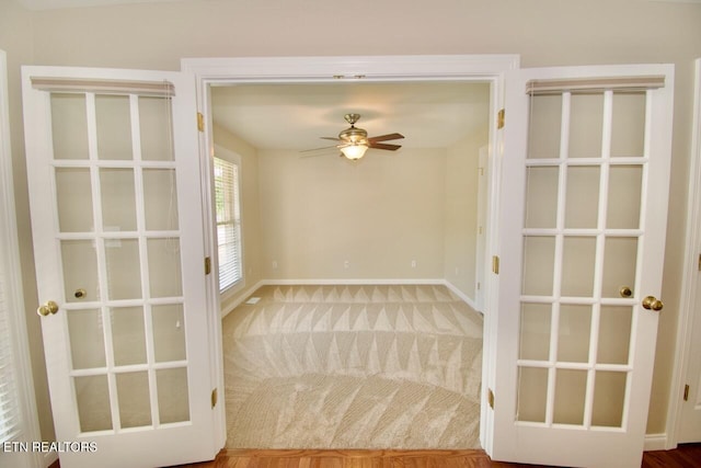 empty room featuring baseboards, a ceiling fan, and carpet