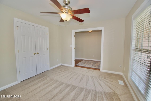 unfurnished bedroom featuring carpet floors, a closet, and multiple windows